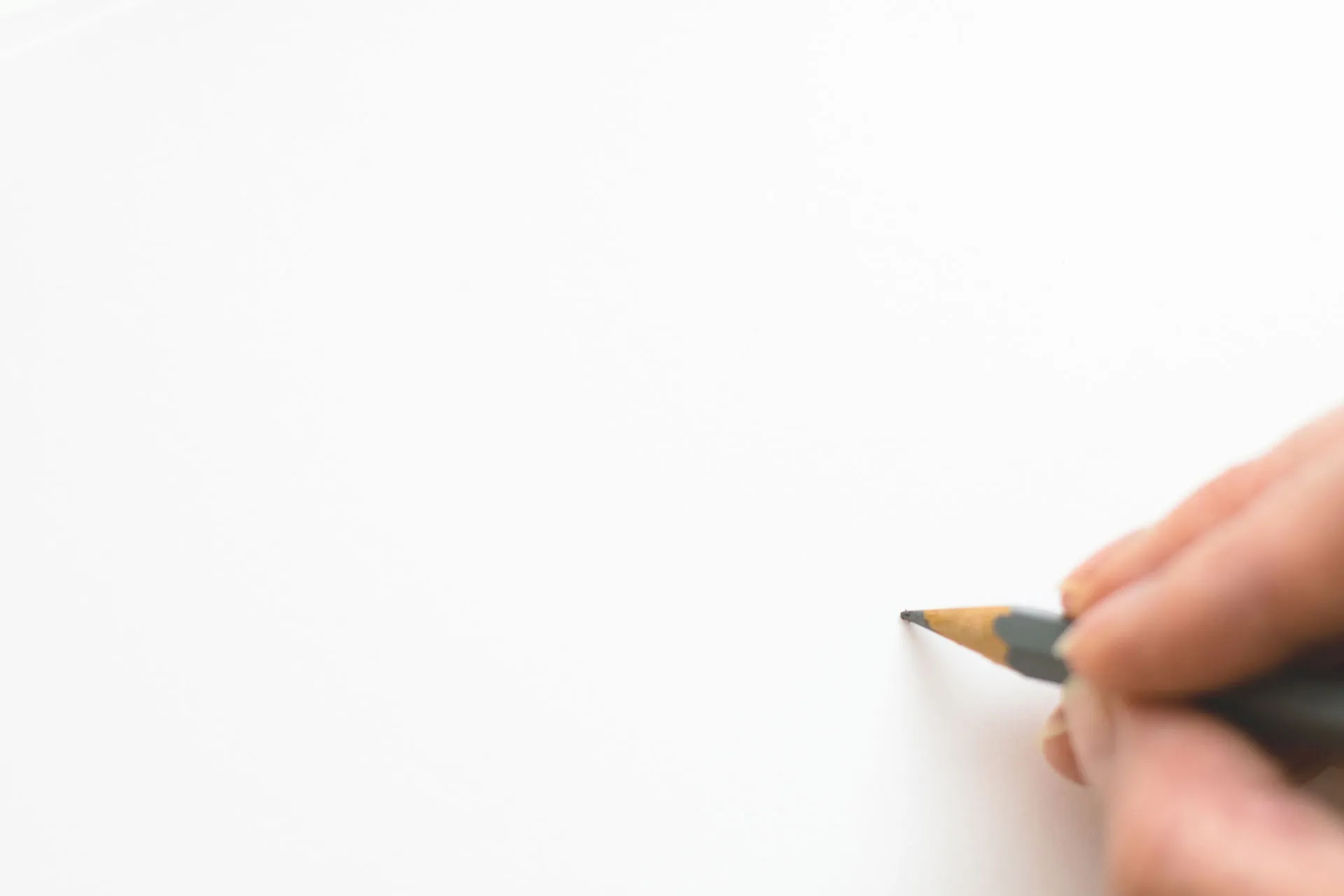 A hand holding a pencil, ready to sign